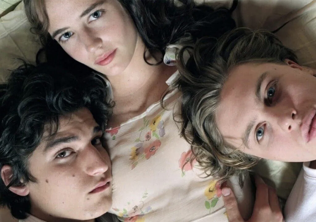 Un frame del film the dreamers, dove i tre protagonisti sono ripresi in primo piano dall’alto mentre sono sdraiati