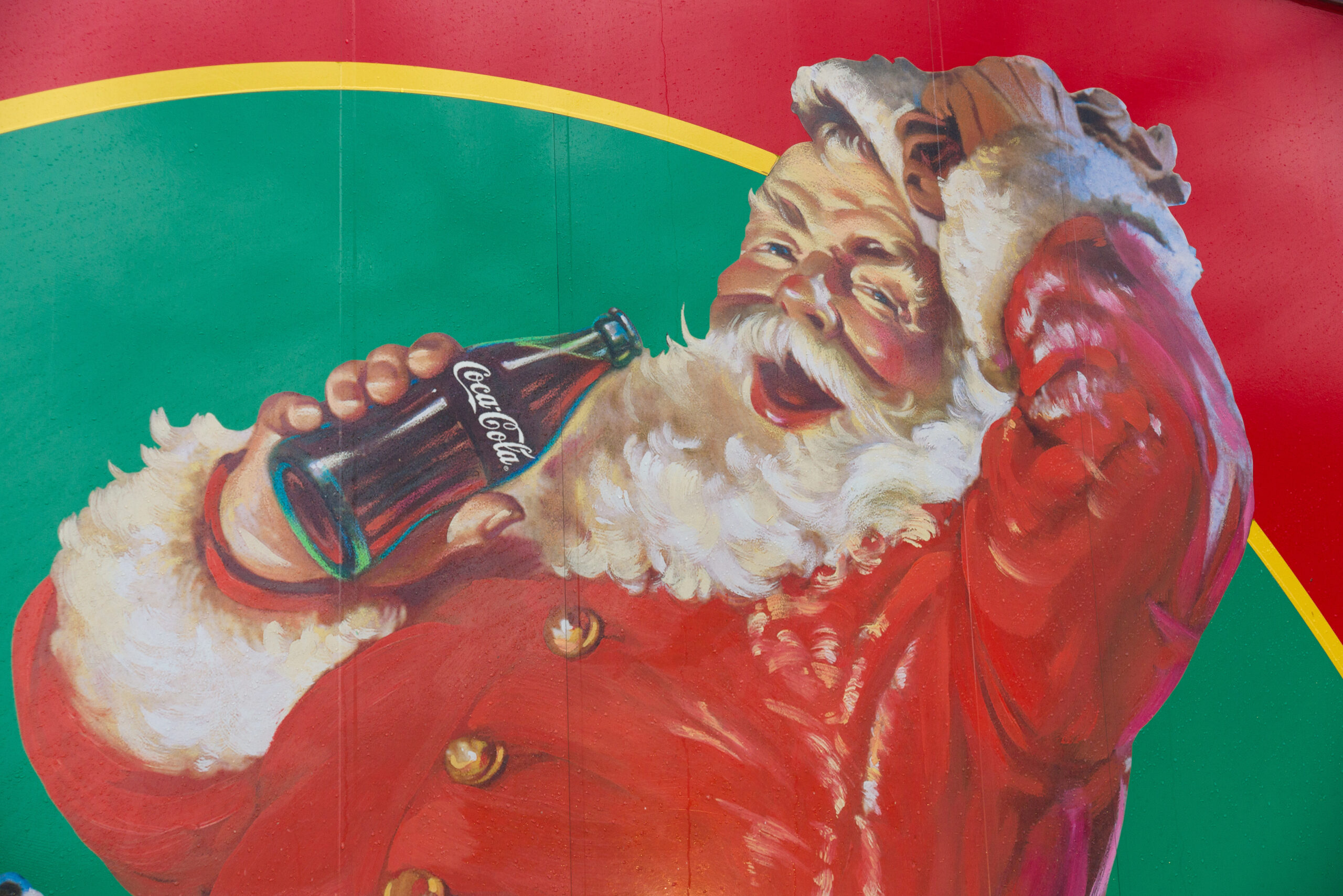 Un manifesto vintage di Babbo Natale che beve la sua Coca Cola, direttamente dall’iconica bottiglia
