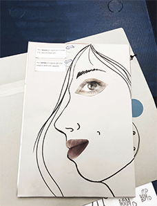 L’immagine di un profilo di donna disegnato con una linea e con labbra e occhi precedentemente ritagliati da un giornale.